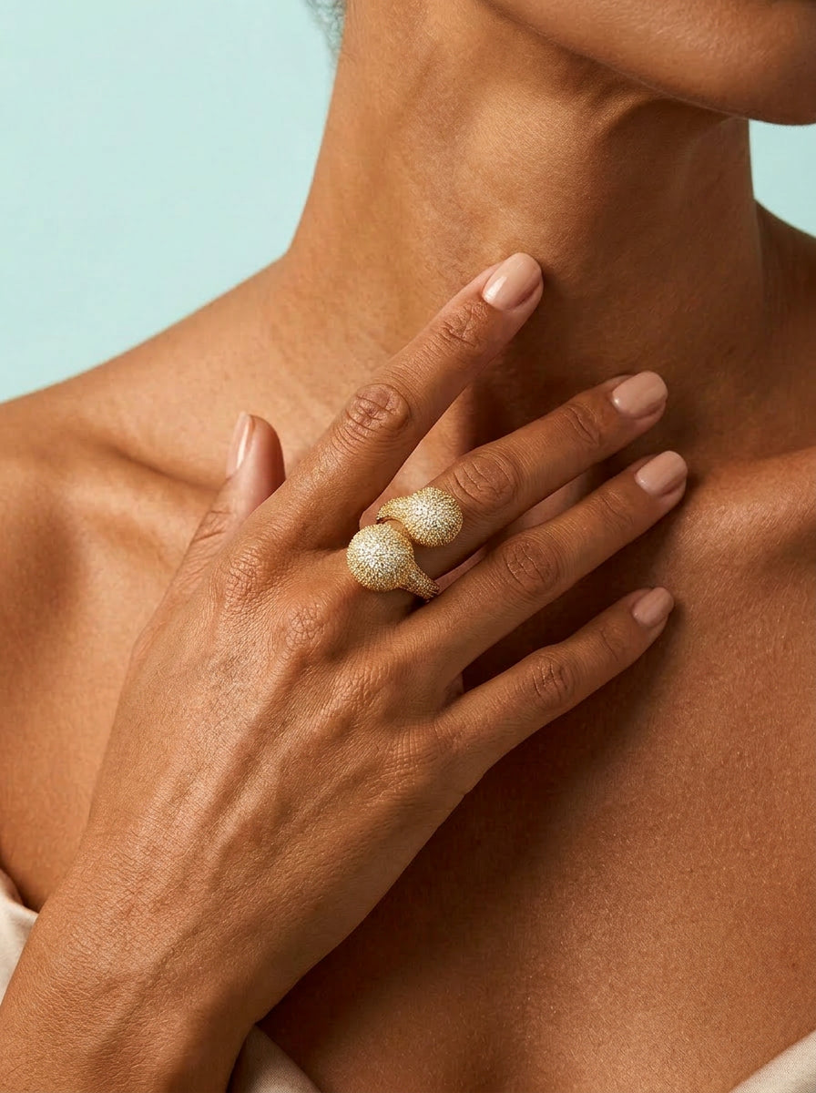 Toned model wearing gold double ball CZ ring
