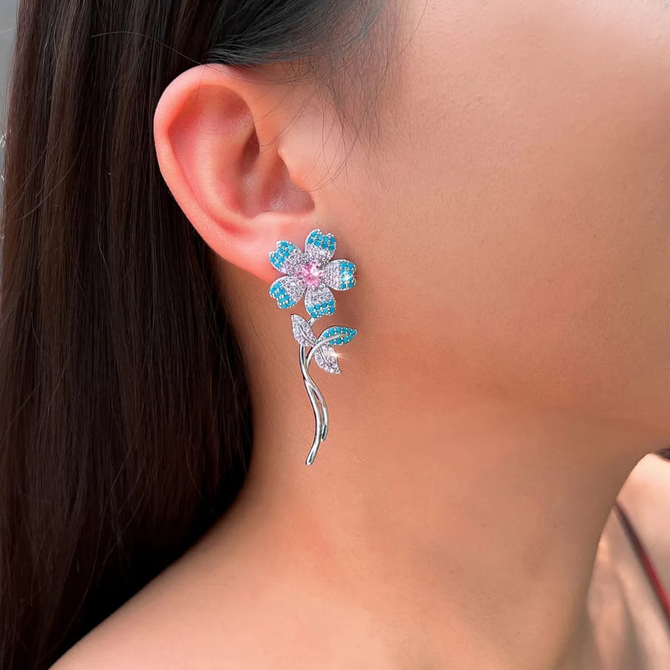 Closeup of turquoise flower pink heart CZ earring on ear