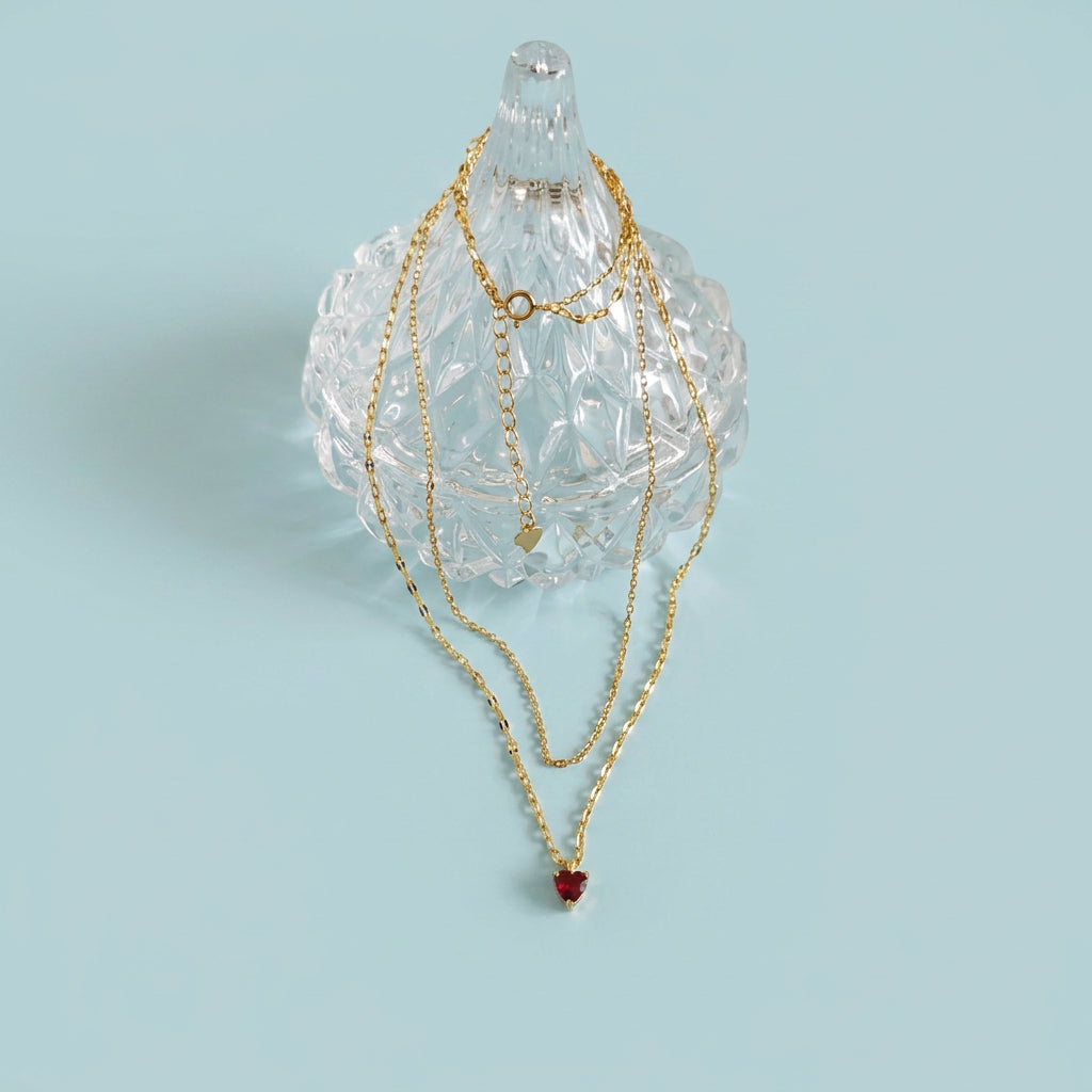 Ruby heart necklace draped on crystal stand